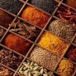 Variety of indian spices in a wooden tray.