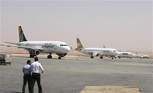 Airport personnel walk in the tarmac after Benghazi airport was re-opened